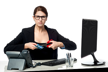 Image showing Serious faced woman cutting her credit card