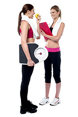 Image showing Female trainer writing diet chart for gym member