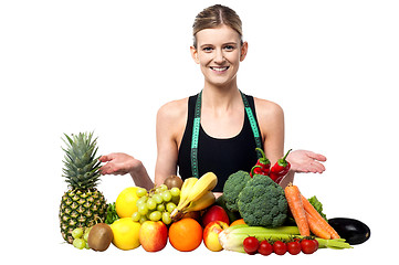 Image showing Young smiling girl presenting fresh fruits