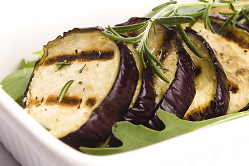 Image showing Grilled eggplant slices on a plate with fresh rosemary