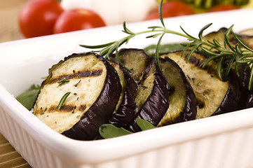 Image showing Grilled eggplant slices on a plate with fresh rosemary