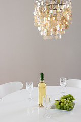 Image showing Decorative chandelier and bottle of wine on the table