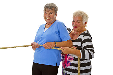 Image showing Two female seniors pulling on a rope