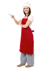 Image showing Female chef pointing towards copy space area