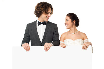 Image showing Married couple posing with a blank ad board
