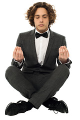 Image showing Guy in tuxedo striking a lotus posture