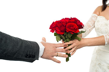 Image showing Bride offering rose bouquet to the groom