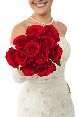 Image showing Smiling young bride holding out a rose bouquet