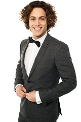 Image showing Young groom buttoning up his blazer