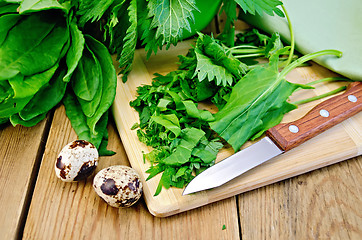 Image showing Sorrel and nettles chopped on the board with quail eggs