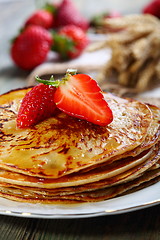 Image showing Pancakes with honey and strawberries.