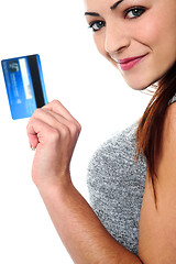 Image showing Fashionable young girl holding up a credit card