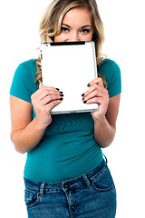 Image showing Shy pretty model hiding face with tablet pc