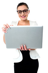Image showing Bespectacled woman holding a laptop