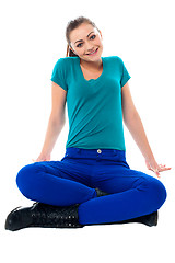 Image showing Cute girl sitting casually on the studio floor