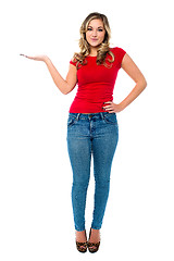 Image showing Young girl in trendy wear presenting something