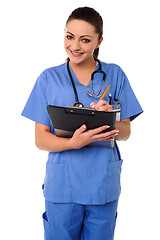 Image showing Cheerful female physician writing prescription