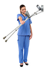 Image showing Sullen faced doctor displaying crutches