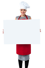Image showing Young baker woman holding a blank whiteboard