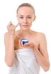 Image showing woman applying cream to her face