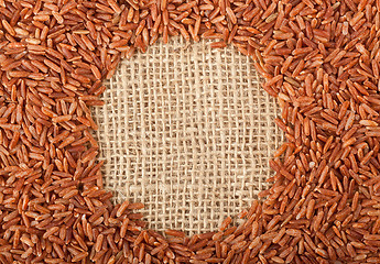 Image showing Brown rice on burlap fabric