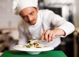 Image showing A chef arranging tossed salad in a white bowl