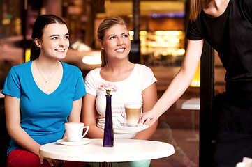 Image showing Two beautiful young girls at coffee shop