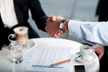 Image showing Business handshake over a coffee