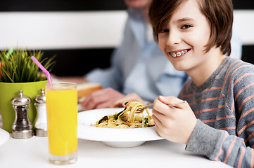 Image showing Boy enjoying food and fresh juice