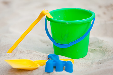 Image showing plastik colorful toys in sand on beach