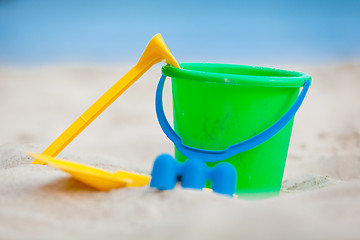 Image showing plastik colorful toys in sand on beach