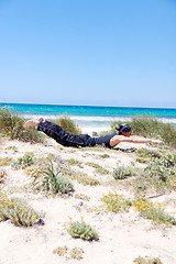 Image showing man doing pilates exercises on beach in summer