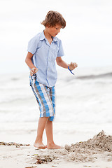 Image showing little boy playing in sand on the beach