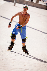 Image showing young man with inline skates in summer outdoor 