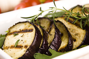 Image showing Grilled eggplant slices on a plate with fresh rosemary