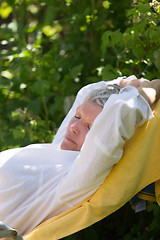 Image showing Senior woman sleeping on lounger