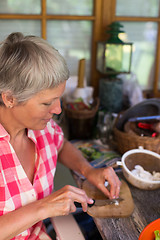 Image showing Senior woman cutting food