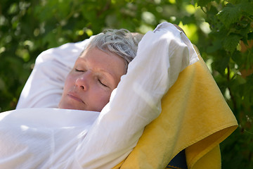 Image showing Senior woman sleeping on lounger