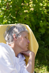 Image showing Aged woman sleeping on lounger