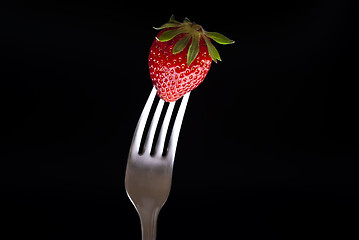 Image showing fresh strawberry on fork isolated on black 