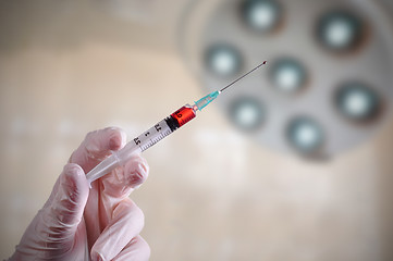 Image showing Hand holding a syringe