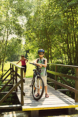 Image showing teenager relaxing on a bike trip on wooden bridge