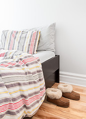 Image showing Warm cozy slippers near bed