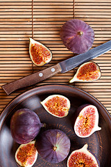 Image showing  plate with fresh figs and old knife on straw background