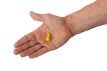 Image showing Hand holding a yellow pawn