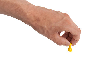 Image showing Hand holding a yellow pawn