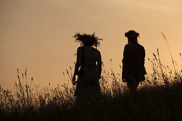 Image showing Silhouettes of People picking flowers during midsummer soltice 