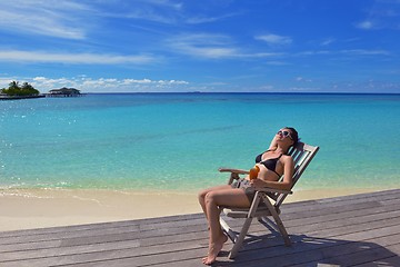 Image showing Beautiful young woman with a drink by the sea