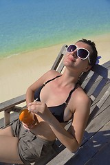 Image showing Beautiful young woman with a drink by the sea