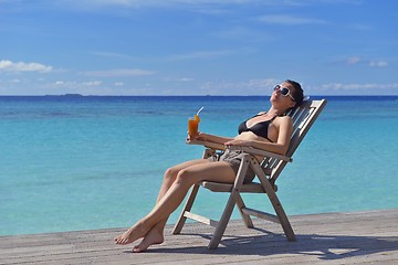 Image showing Beautiful young woman with a drink by the sea